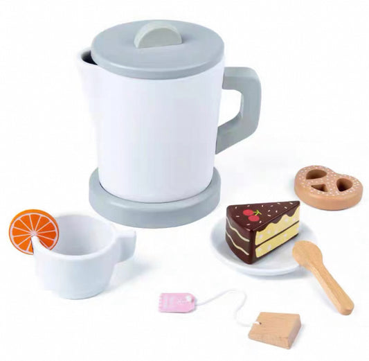 Cucinino fa vízforraló játékszett az asztalon, csészével, tortaszelettel és pereccel.