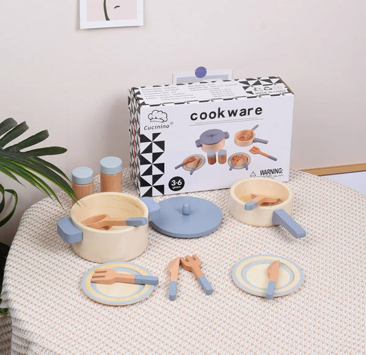 Fából készült játékkonyhai edénykészlet lábassal, serpenyővel, tányérokkal és evőeszközökkel.